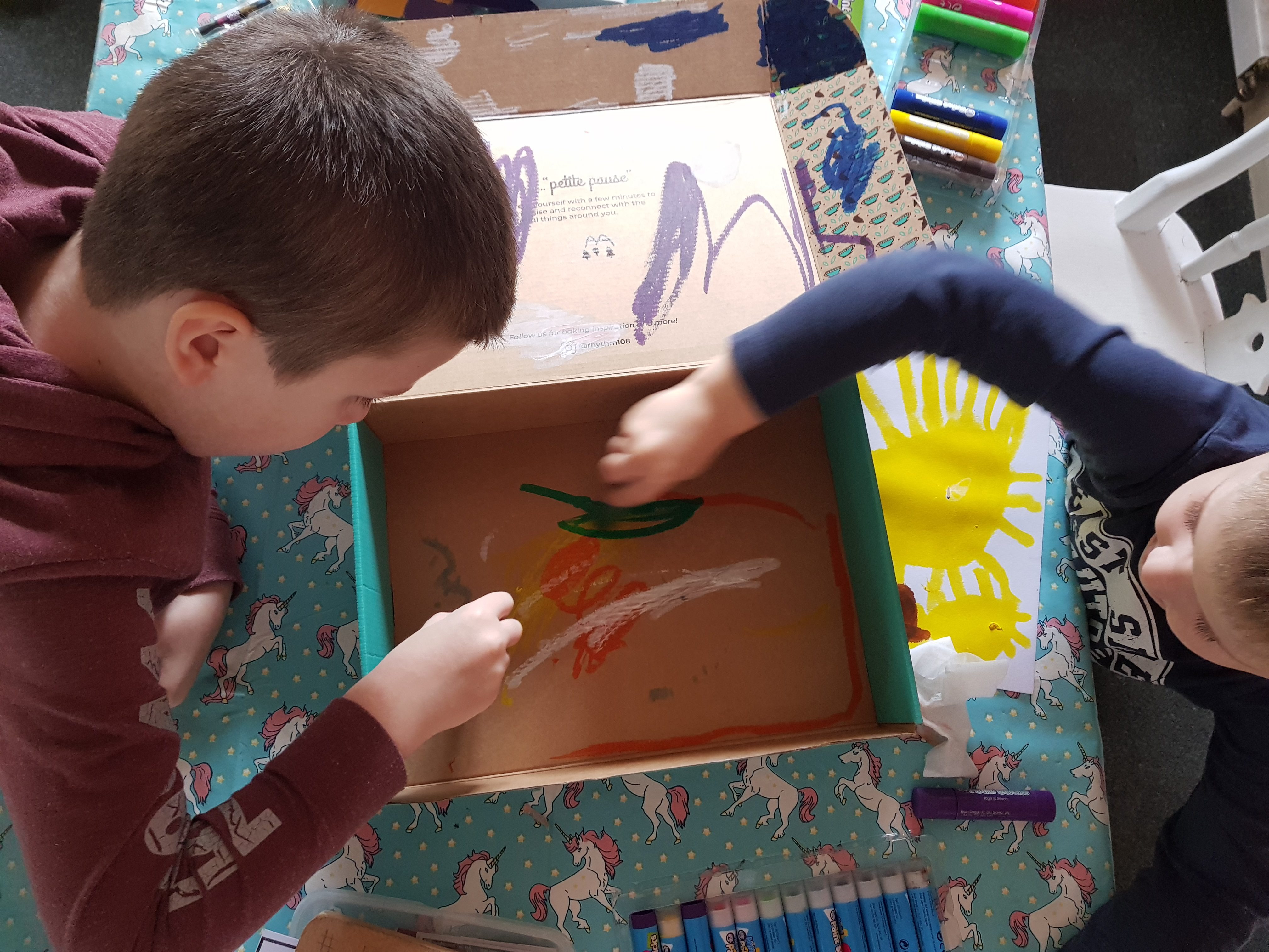 Boys using Little Brian paint sticks on box