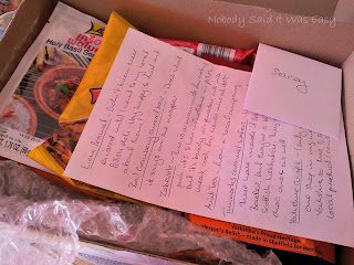 a box containing food products with a piece of paper with writing on the top; Foodie Penpals July reveal