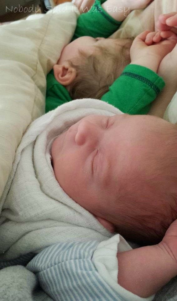 Two children asleep next to each other in bed