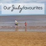 A photo of a beach with people in the far distance. The text on the photo says Our July Favourites