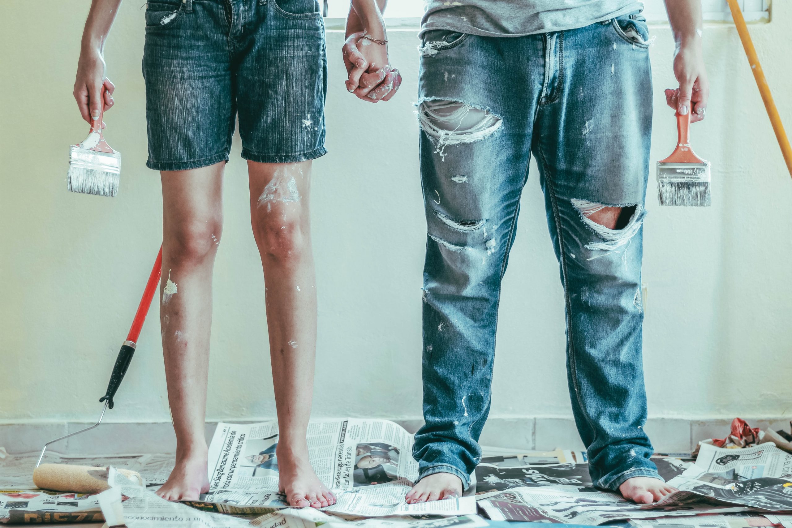 woman and a man covered in paint holding painting implements