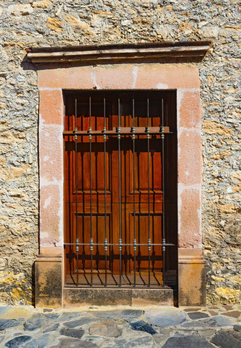 brown door covered by an iron grate; How To Improve The Security Of Your Family Home