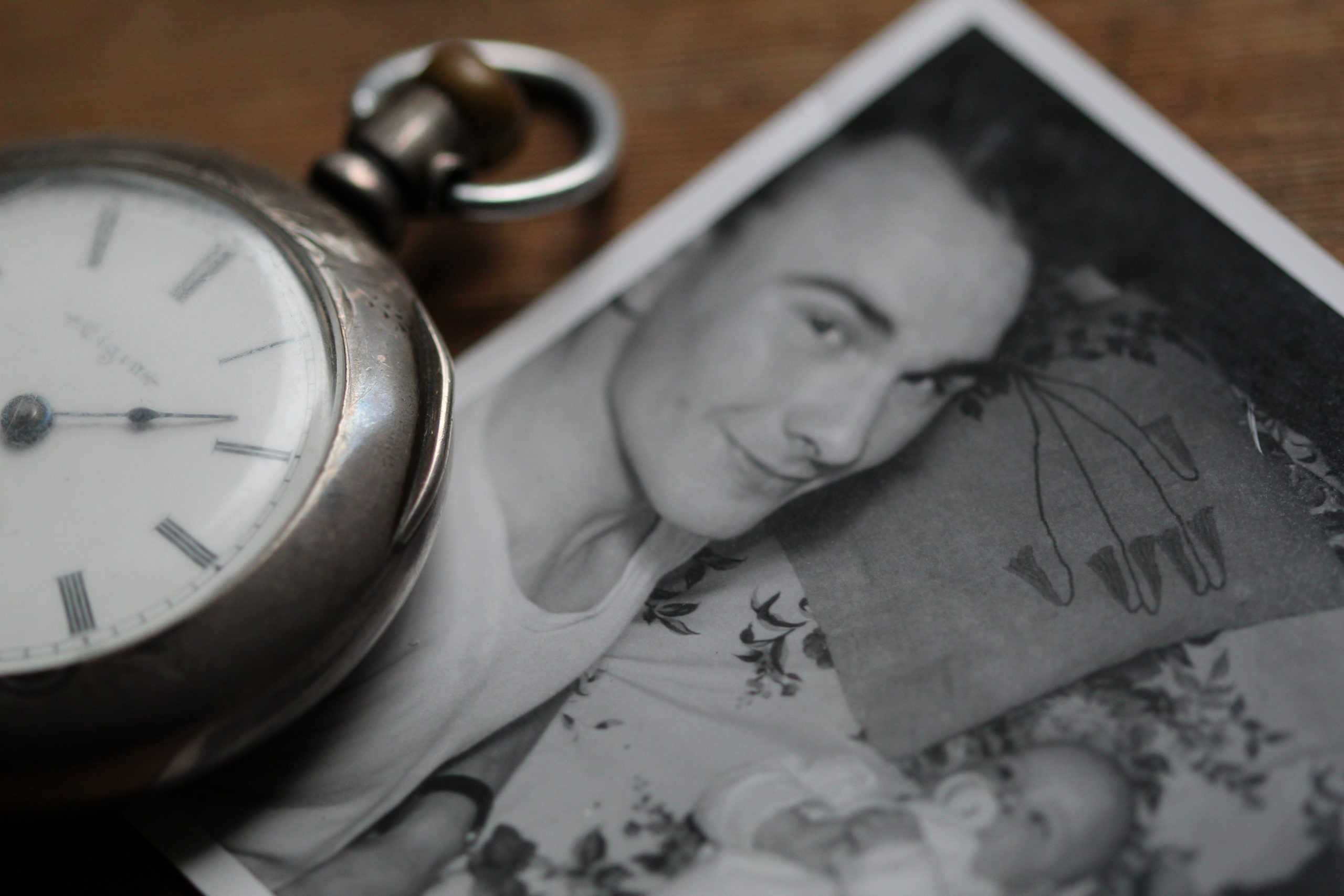 black and white photo of a man and baby with a pocket watch next to it