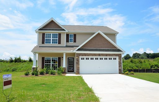 a large house at the end of a driveway; Moving Into Your First Home Get These Done