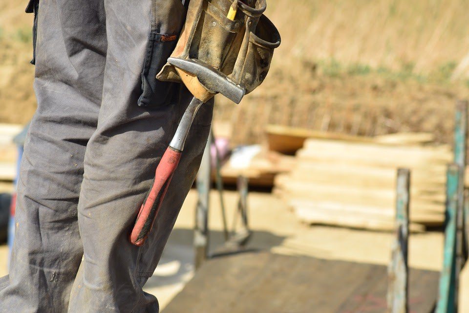 a man carrying tools including a hammer; Boosting Your Home Improvement Ideas