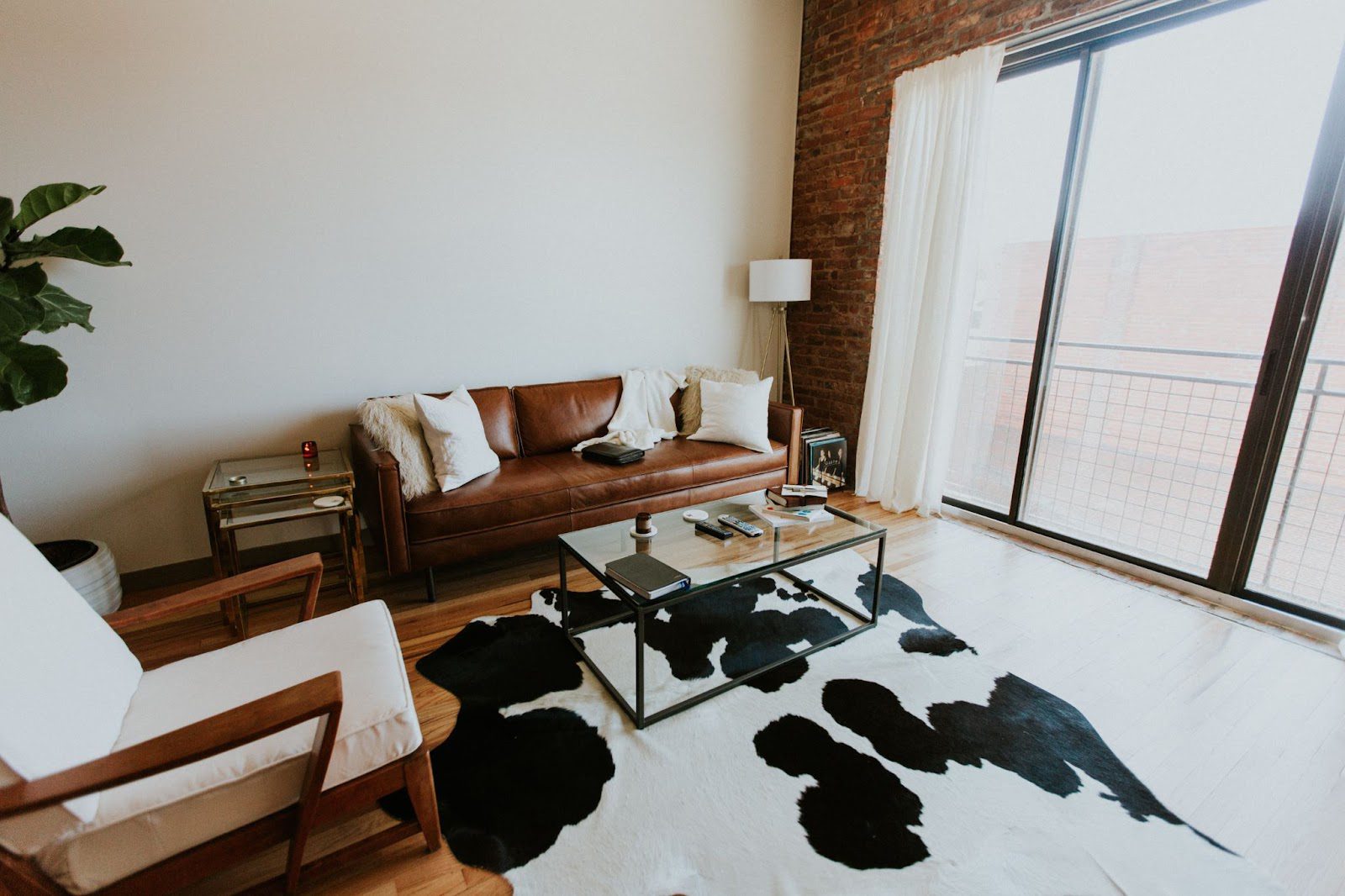 living area with glass table, brown sofa and cow print rug; 5 Easy Steps To Remodel Your Home