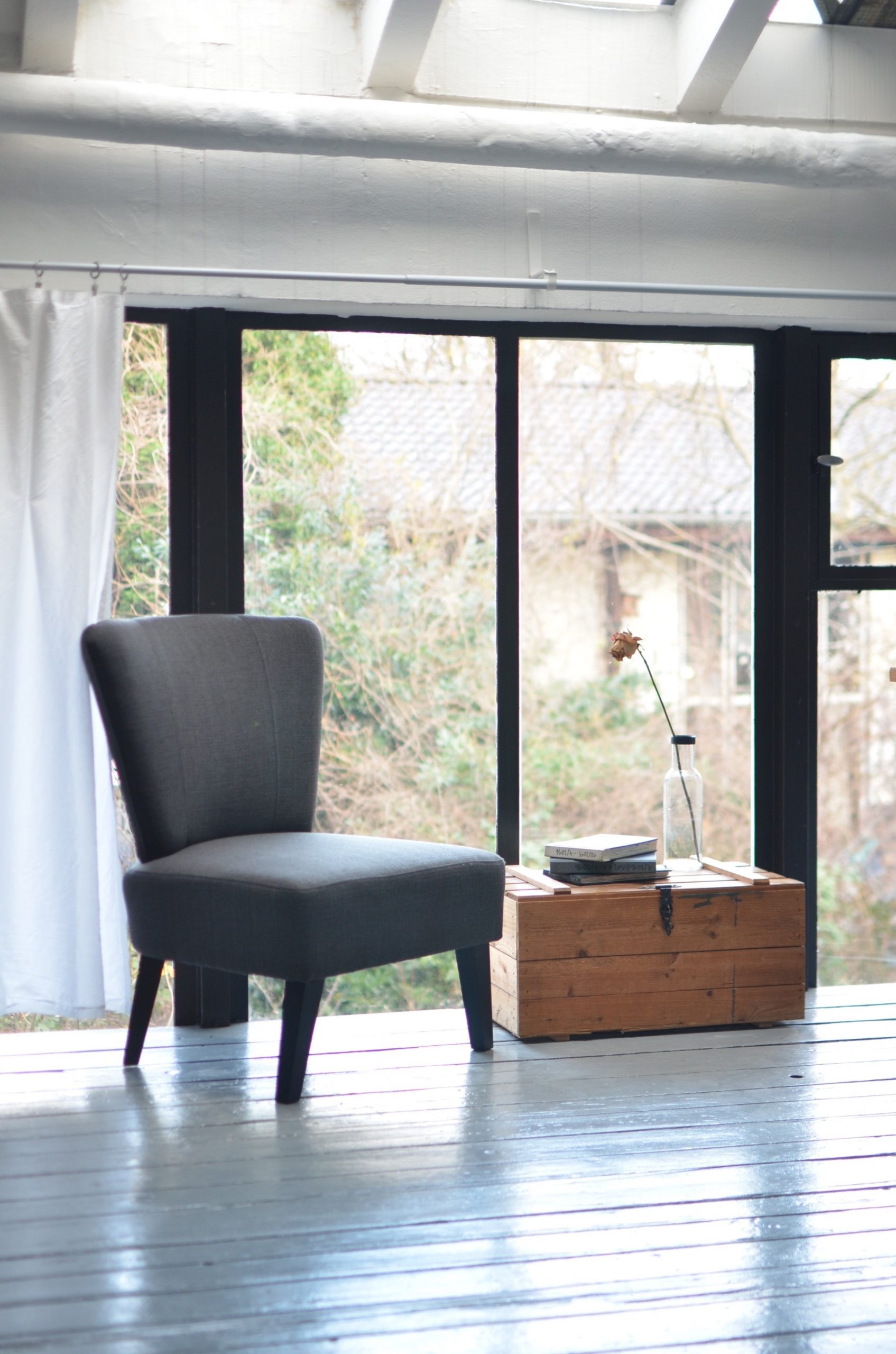 comfy soft grey chair and brown wooden table in a garden room