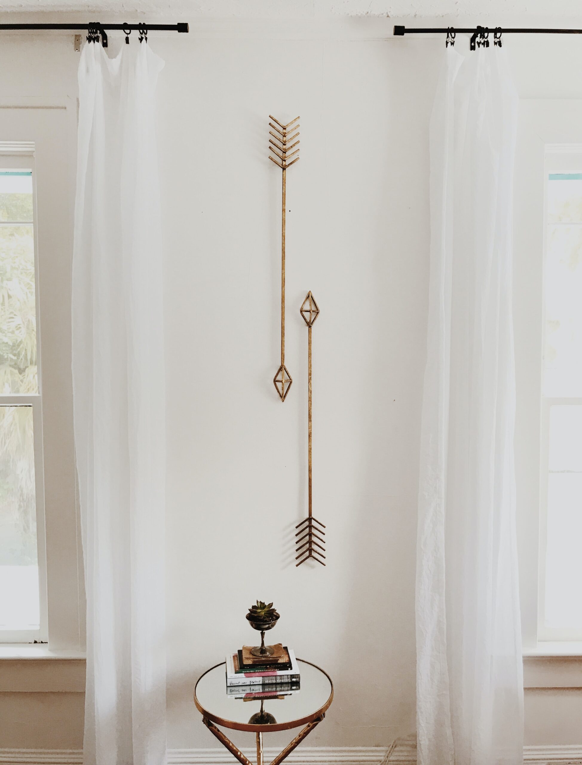 two golden metal arrows as decoration on a white wall; The Anatomy Of A Bespoke Interior