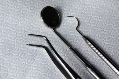 A set of metal dental tools on a white sheet; What To Look For In A New Dental Practice: A Practical Guide