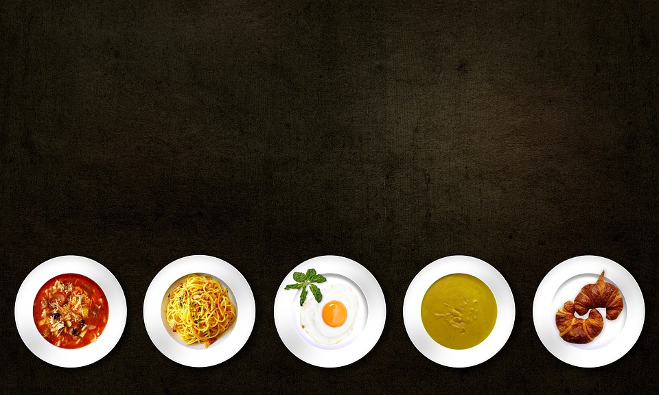 five round white plates on a black background, with a variety of dishes on each plate; 3 Foods You Need To Try