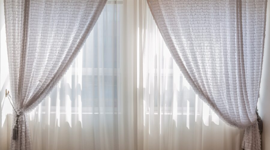 a large window with light shining through behind white netting; Classic Decor You Need for Every Room