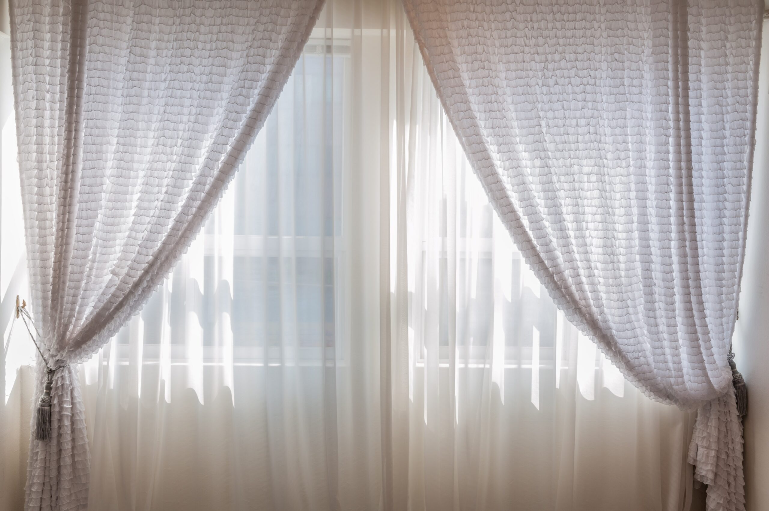 a large window with light shining through behind white netting; Classic Decor You Need for Every Room