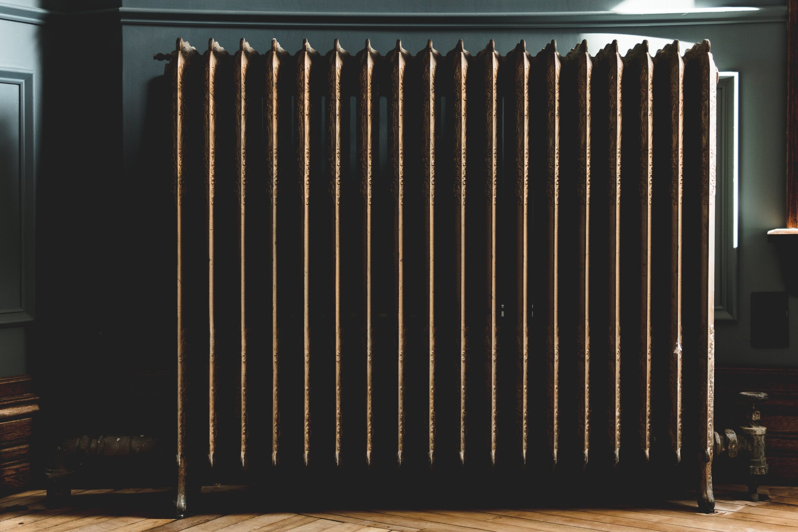 a dark coloured radiator against a dark wall; Why Underfloor Heating Is Gaining More Popularity These Days