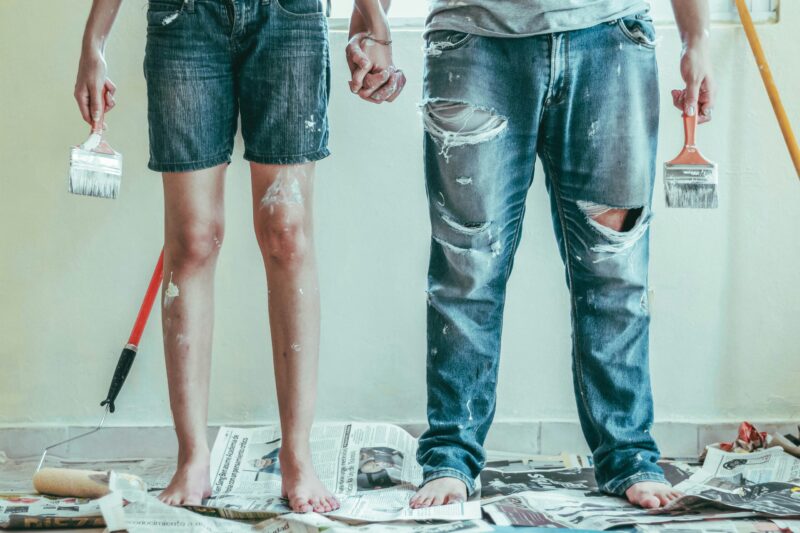 a couple in denim jeans with paint and DIY maetirals around them. You can only see them from the wasit up; 5 DIY Tips To Help With Any Project