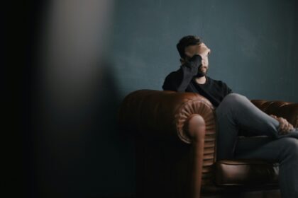A man holding his head in his hands while sitting on a sofa; How to Mentally Recover After a Motorcycle Accident