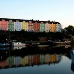 A body of water at Bristol harbourside. There are a row of colourful buildings along the waterfront and these are reflecting in the water. There are also a number of boats in the water; Escaping the Everyday: Where to Go When You Need a Reset