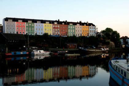 A body of water at Bristol harbourside. There are a row of colourful buildings along the waterfront and these are reflecting in the water. There are also a number of boats in the water; Escaping the Everyday: Where to Go When You Need a Reset