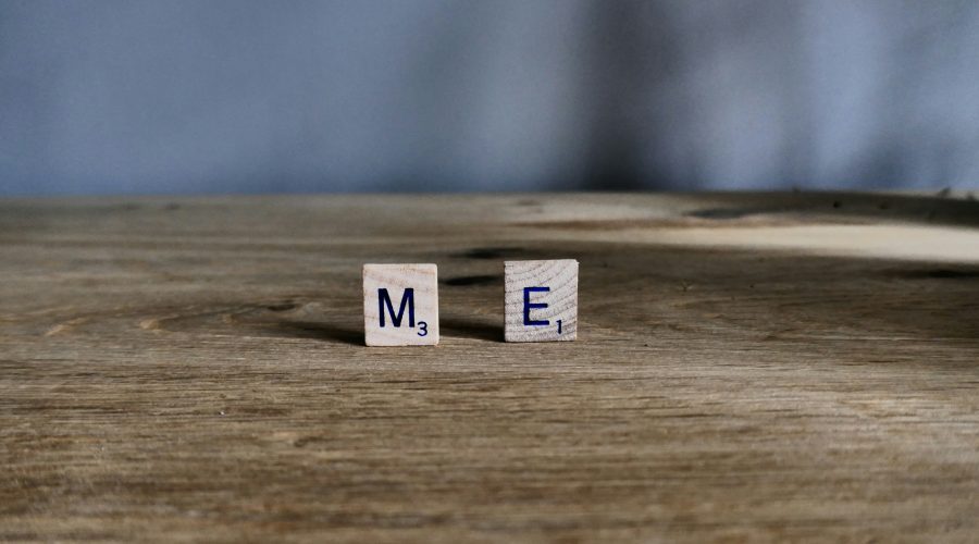two scrabble tiles on a wooden surface spelling out M E; An Honest Explanation Of Living With MECFS
